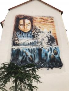 Frau & Wolf am Wasserfall - auf Wohnhausfassade
