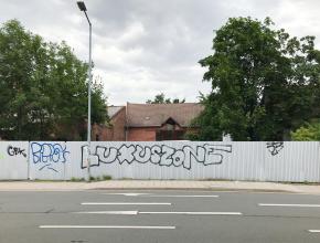 Schriftzug auf Wellblechzaun