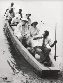 Albert Schweitzer und Mitarbeiter auf einem kleinen Boot.