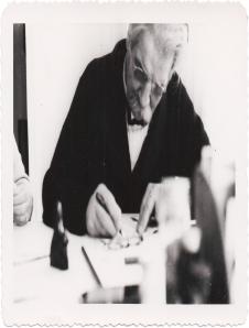 Albert Schweitzer beim Schreiben von Autogrammen